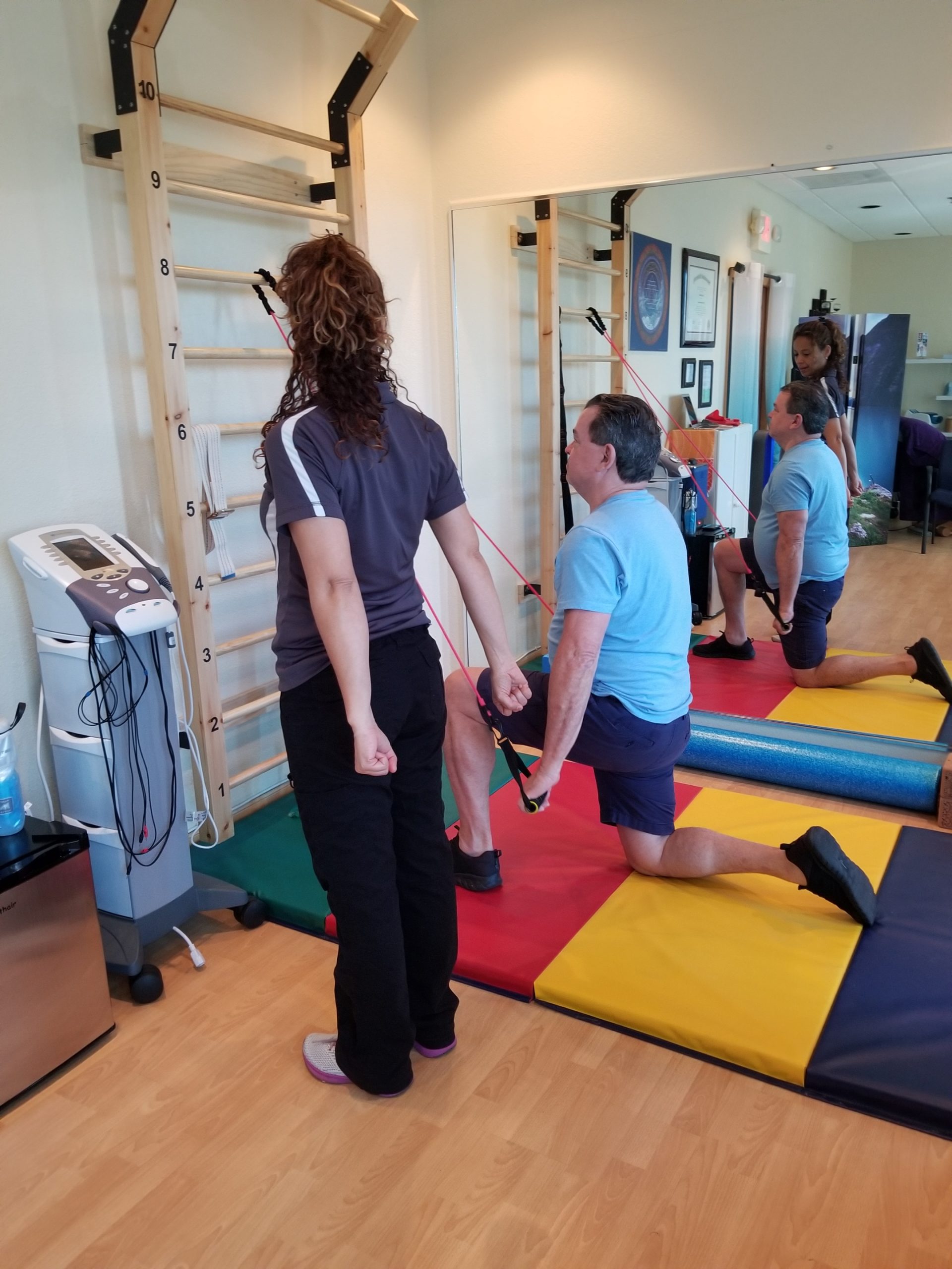 Dr. Evelyn Mora guiding a patient through shoulder blade strengthening exercises for upper back pain in Pembroke Pines