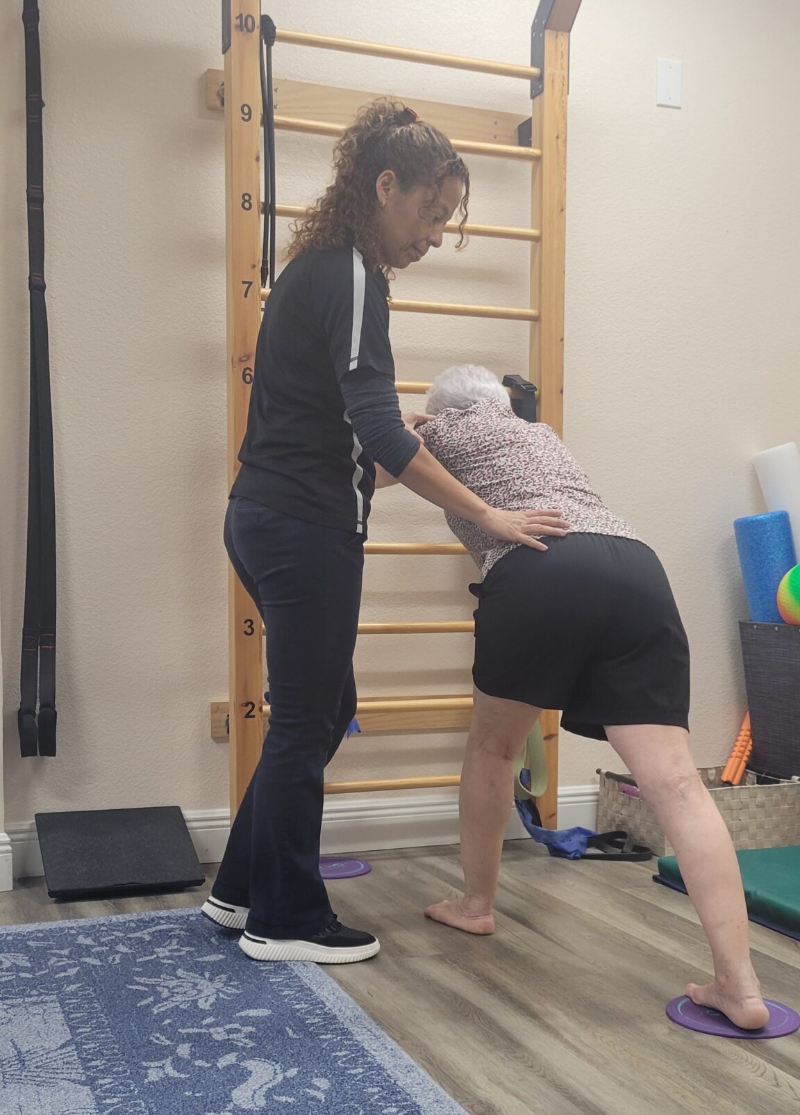 Dr. Evelyn Mora helping a patient improve posture and movement patterns for upper back pain in Pembroke Pines